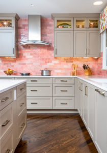 kitchen with white cabinets and pink backsplash tile